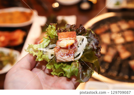 Korean bbq. ssam : eat pork wrapped in lettuce leaves 129709087