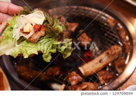Korean bbq. ssam : eat pork wrapped in lettuce leaves Korean bbq. ssam : eat pork wrapped in lettuce leaves 129709094