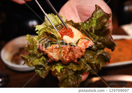 Korean bbq. ssam : eat pork wrapped in lettuce leaves Korean bbq. ssam : eat pork wrapped in lettuce leaves 129709097