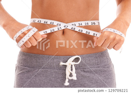 Fitness, health and woman with tape measure for stomach in studio isolated on a white background. Diet, wellness and slim female model measuring waist to track weightloss goals, progress or targets. Fitness, health and woman with tape measure for stomach in studio isolated on a white background. Diet, wellness and slim female model measuring waist to track weightloss goals, progress or targets. 129709221