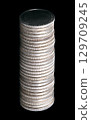Column of neatly stacked silver coins, against a black background. Stack of twenty-eight circulated silver bullion coins with reeded edges, each of one troy ounce of 99.9 percent pure silver. Photo 129709245