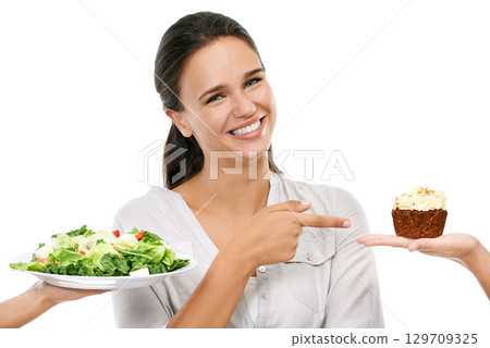 Salad, cake and woman with unhealthy decision in studio for food, sugar and diet marketing. Chocolate cupcake, green vegetable and model happy decision or hand sign on white background and mockup Salad, cake and woman with unhealthy decision in studio for food, sugar and diet marketing. Chocolate cupcake, green vegetable and model happy decision or hand sign on white background and mockup 129709325