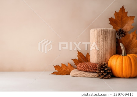 White background with a pumpkin, pine cone, and two knit hats White background with a pumpkin, pine cone, and two knit hats 129709415