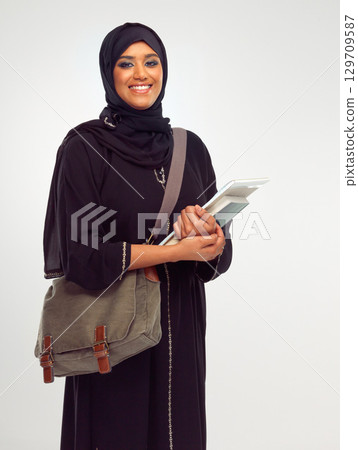 Portrait, muslim and study with a student woman holding books in studio on a gray background for learning or education. Islam, university and an islamic female at college campus on a scholarship 129709587