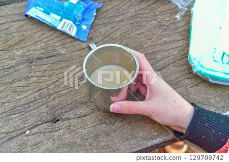 woman's hand holding a cup 129709742