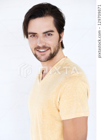 Fashion, happy and portrait of a man in a studio with casual, stylish and trendy clothes. Friendly, smile and young male model from Spain with a modern style outfit isolated by a white background. 129709871