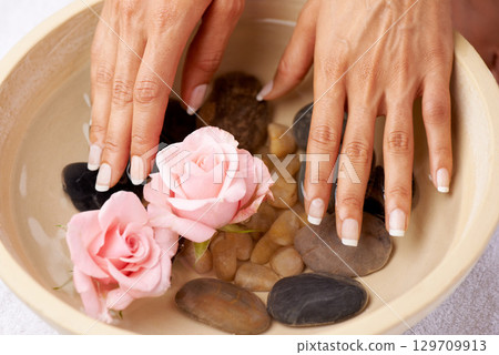 Skincare, flowers and hands of woman in water bowl for cleaning or hygiene. Floral therapy, spa treatment and female soak hand and washing with pink roses and stones for detox, beauty and manicure. Skincare, flowers and hands of woman in water bowl for cleaning or hygiene. Floral therapy, spa treatment and female soak hand and washing with pink roses and stones for detox, beauty and manicure. 129709913
