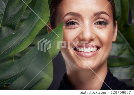 Beauty, skin and face with leaf and woman, skincare with nature aesthetic, natural cosmetics and facial portrait against studio background. Smile, glow with organic cosmetic treatment and wellness. Beauty, skin and face with leaf and woman, skincare with nature aesthetic, natural cosmetics and facial portrait against studio background. Smile, glow with organic cosmetic treatment and wellness. 129709997