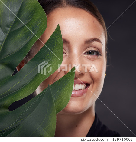 Beauty, skin and face with leaf and woman, skincare with nature aesthetic, natural cosmetics and facial portrait against studio background. Smile, glow with organic cosmetic treatment and wellness. 129710005