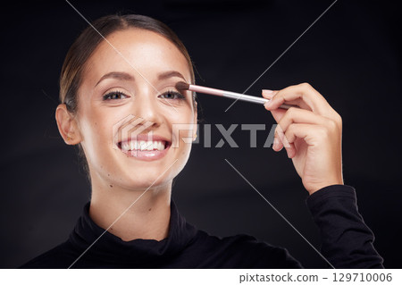 Makeup, brush or portrait of woman in studio with beauty cosmetics, eyeshadow or facial products on black background. Makeup artist, smile or happy girl brushes face for luxury skincare grooming Makeup, brush or portrait of woman in studio with beauty cosmetics, eyeshadow or facial products on black background. Makeup artist, smile or happy girl brushes face for luxury skincare grooming 129710006
