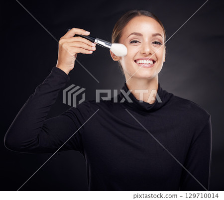 Makeup, brush or portrait of woman in studio with beauty cosmetics or facial foundation products on black background. Makeup artist, smile or happy girl brushes face for luxury skincare grooming Makeup, brush or portrait of woman in studio with beauty cosmetics or facial foundation products on black background. Makeup artist, smile or happy girl brushes face for luxury skincare grooming 129710014