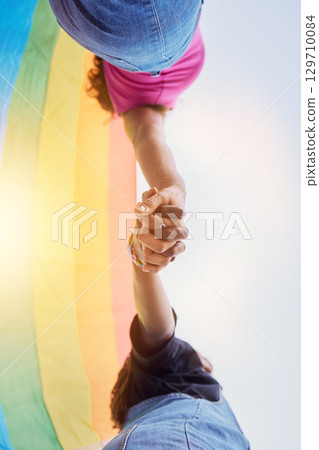LGBTQ community, rainbow flag and couple holding hands for human rights protest, solidarity and gay lesbian support. Queer, sky and black people together in love, partnership and equality below view 129710084