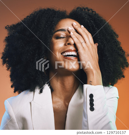 Happy black woman, face and hand with hair and beauty, manicure and hair care with afro against studio background. Funny, pride and cosmetic skincare, facial and natural curly hair texture with laugh 129710137