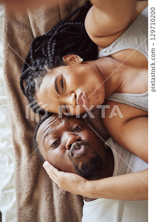 Black couple, love and bedroom selfie while happy and funny together, pouting on bed at home, apartment or hotel. Portrait of a young man and woman in a happy marriage with commitment in top view Black couple, love and bedroom selfie while happy and funny together, pouting on bed at home, apartment or hotel. Portrait of a young man and woman in a happy marriage with commitment in top view 129710200