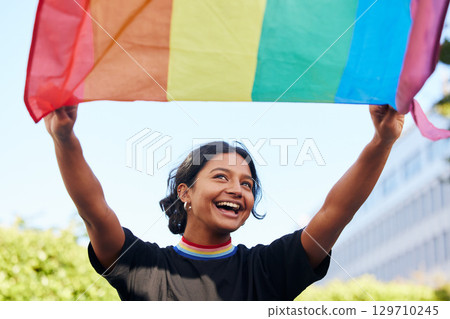 Rainbow, flag and lgbt with an indian woman in the city in celebration of human rights, equality or freedom. Community, support and gay with a gender neutral or non binary female celebrating lgbtq 129710245