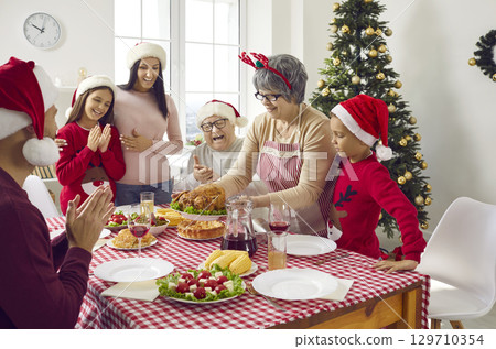 Merry Christmas. A happy family is having dinner at home. Merry Christmas. A happy family is having dinner at home. 129710354