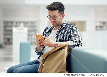 Library, reading and man with book on sofa for education, studying and academic research. University, scholarship and student with backpack learning, reading book and knowledge in college bookstore Library, reading and man with book on sofa for education, studying and academic research. University, scholarship and student with backpack learning, reading book and knowledge in college bookstore 129710357