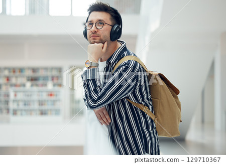 Thinking, headphones and library student at university, college or academy idea for research, learning and knowledge. Study, education and creative, geek man listening to audio for school inspiration 129710367