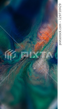 Blur ink wave. Shiny fluid. Defocused blue orange green color particles glitter texture floating on abstract acrylic art background. 129710429