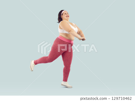 Full length shot of funny chubby overweight woman doing sports 129710462