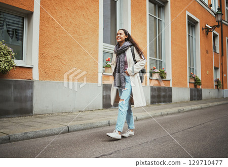 Happy, relax and woman in the city street for travel adventure, walking and thinking on a vacation in Italy. Peace, idea and traveler girl in a vintage road traveling a town during a holiday 129710477