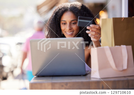 Credit card, laptop and woman in city online shopping, e commerce and fintech for fashion marketing, advertising and promotion sales. Black woman on digital e commerce website for finance banking app 129710610