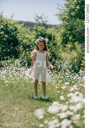 Girl Daisies Field: Child with flower crown in meadow on sunny day, enjoying summer beauty/ nature. Girl Daisies Field: Child with flower crown in meadow on sunny day, enjoying summer beauty/ nature. 129710668