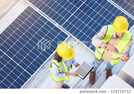 Solar energy, team and tablet on roof planning or focus for sustainability for future of urban city. Engineering team, mobile tech or photovoltaic solar panel for clean eco friendly energy on rooftop 129710732