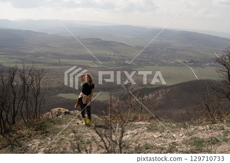 Landscape Woman Mountain: Woman views landscape in mountains, enjoys nature, observes beauty, daytime. 129710733