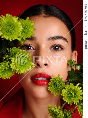 Beauty, flowers and face with woman and lipstick, natural cosmetics with nature, skincare and organic treatment against red studio background. Lips, portrait and microblading, eyebrow care and makeup 129710765