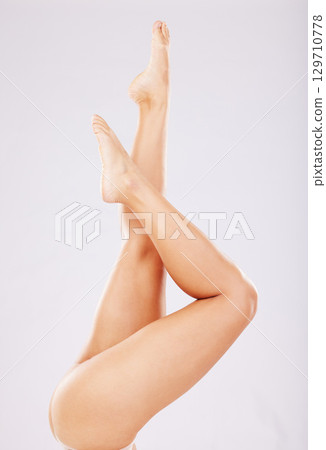 Skincare, legs and woman with cosmetics, wellness and clear skin against grey studio background. Leg, feet and female with smooth treatment, glow or shine with grooming, natural beauty or luxury care Skincare, legs and woman with cosmetics, wellness and clear skin against grey studio background. Leg, feet and female with smooth treatment, glow or shine with grooming, natural beauty or luxury care 129710778