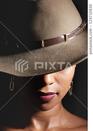 Woman, dark studio and hat for fashion, beauty and mystery with style, design or closeup headshot. Girl, model and black background for fantasy, night aesthetic or makeup for edgy, sexy woman and art Woman, dark studio and hat for fashion, beauty and mystery with style, design or closeup headshot. Girl, model and black background for fantasy, night aesthetic or makeup for edgy, sexy woman and art 129710830