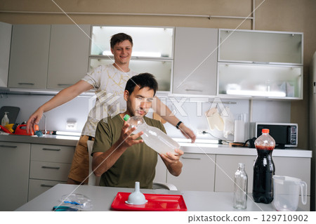 Two biologists preparing fertilizer solution, mixing ingredients in controlled laboratory kitchen environment, ensuring precise measurements for optimal plant growth. Concept of urban farming. 129710902