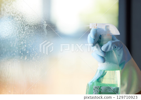 Hands, window and cleaning bacteria spray for surface disinfection, home hygiene and chemical cleaner. Housekeeping, windows and glass interior with soap foam protection cleaning products in bottle 129710923