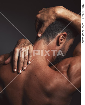 Stretching, fit man and back muscle on dark black studio background. Self love, self care and model embracing skin, confidence and body positivity with an artistic body hug and creative expression 129710987