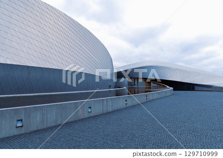 Nation Aquarium Denmark, Den Bla Planet. Modern building against the beautiful sunset sky Nation Aquarium Denmark, Den Bla Planet. Modern building against the beautiful sunset sky 129710999