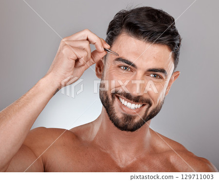 Man, eyebrow tweezers and face hair removal for skincare beauty, grooming wellness and hygiene happiness in grey studio background. Model smile, cosmetics facial care and dermatology or microblading 129711003