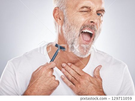 Man, face or neck shaving injury on gray studio background in self care grooming, healthcare wellness or beard beauty aesthetic. Portrait, mature model or hair removal pain with cleaning facial razor Man, face or neck shaving injury on gray studio background in self care grooming, healthcare wellness or beard beauty aesthetic. Portrait, mature model or hair removal pain with cleaning facial razor 129711059