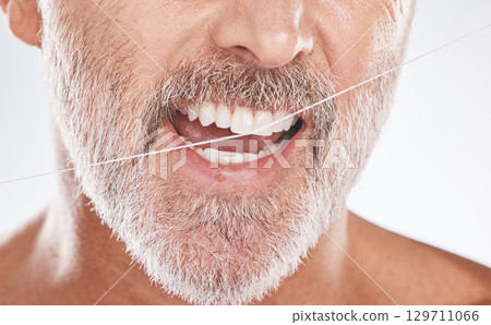 Floss, dental and face of senior man in studio isolated on a gray background. Cleaning, hygiene and elderly male model with product flossing teeth for oral wellness, tooth care and healthy mouth. Floss, dental and face of senior man in studio isolated on a gray background. Cleaning, hygiene and elderly male model with product flossing teeth for oral wellness, tooth care and healthy mouth. 129711066