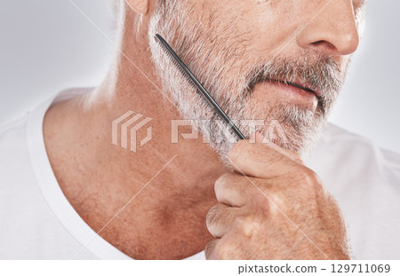 Face, senior man and beard comb in studio isolated on a gray background. Skincare, facial hair care and elderly retired male model with product, tool or accessory for grooming, beauty and aesthetics. 129711069
