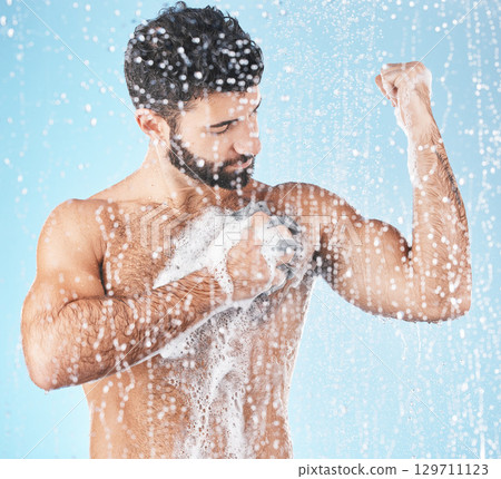 Shower, water and man cleaning with soap for body care, washing and hygiene on blue background in studio. Grooming routine, bathroom and torso of male with foam sponge for skincare, wellness and spa Shower, water and man cleaning with soap for body care, washing and hygiene on blue background in studio. Grooming routine, bathroom and torso of male with foam sponge for skincare, wellness and spa 129711123