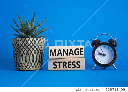 Manage stress symbol. Concept word Manage stress on wooden blocks. Beautiful blue background with alarm clock and succulent plant. Business and Manage stress concept. Copy space 129711409