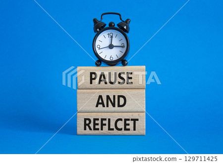 Pause and Reflect symbol. Concept words Pause and Reflect on wooden blocks. Beautiful blue background with alarm clock. Business and Pause and Reflect concept. Copy space. Pause and Reflect symbol. Concept words Pause and Reflect on wooden blocks. Beautiful blue background with alarm clock. Business and Pause and Reflect concept. Copy space. 129711425