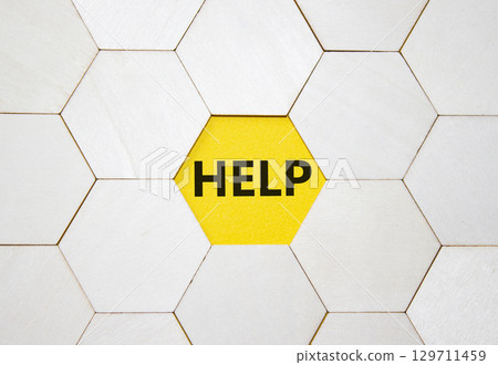 Help symbol. Concept word help on wooden comb puzzle. Beautiful yellow background. Business and help concept. Copy space. Help symbol. Concept word help on wooden comb puzzle. Beautiful yellow background. Business and help concept. Copy space. 129711459