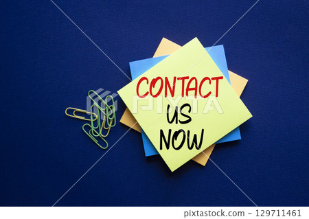 Contact us now symbol. Sticky notes with words Contact us now. Beautiful deep blue background. Business and Contact us now concept. Copy space. 129711461