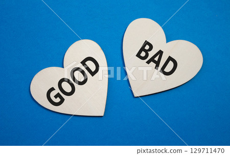 Good or Bad symbol. Concept word Good or Bad on wooden hearts. Beautiful blue background. Business and Good or Bad concept. Copy space Good or Bad symbol. Concept word Good or Bad on wooden hearts. Beautiful blue background. Business and Good or Bad concept. Copy space 129711470