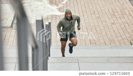 Fitness, runner or black man running on stairs for training, exercise or cardio workout in Chicago. Mission, mindset or healthy athlete in hoodie with motivation or sports goals exercising on steps 129711603