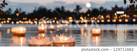 Asian festival Yi Peng lanterns floating on water at night, background 129711662