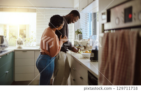 Black couple, cooking and helping with food in kitchen at home while together to cook healthy food. Happy young man and woman in their house or apartment to bond and prepare lunch or dinner with love Black couple, cooking and helping with food in kitchen at home while together to cook healthy food. Happy young man and woman in their house or apartment to bond and prepare lunch or dinner with love 129711718