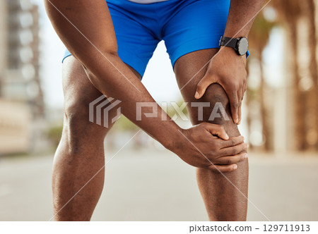 Fitness, pain in knee and hands of black man with muscle ache, joint pain and injury after running in city. Sports, body wellness and male athlete rest after workout, marathon training and exercise Fitness, pain in knee and hands of black man with muscle ache, joint pain and injury after running in city. Sports, body wellness and male athlete rest after workout, marathon training and exercise 129711913